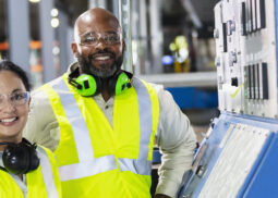 two manufacturing workers next to machine