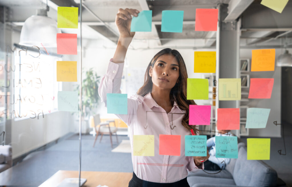 Woman making a business plan at the office using adhesive notes on the board