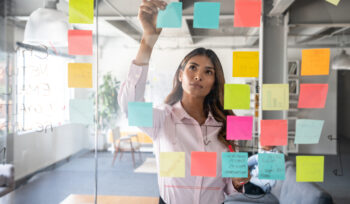 Woman making a business plan at the office using adhesive notes on the board