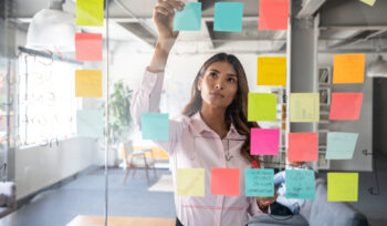 Woman making a business plan at the office using adhesive notes on the board